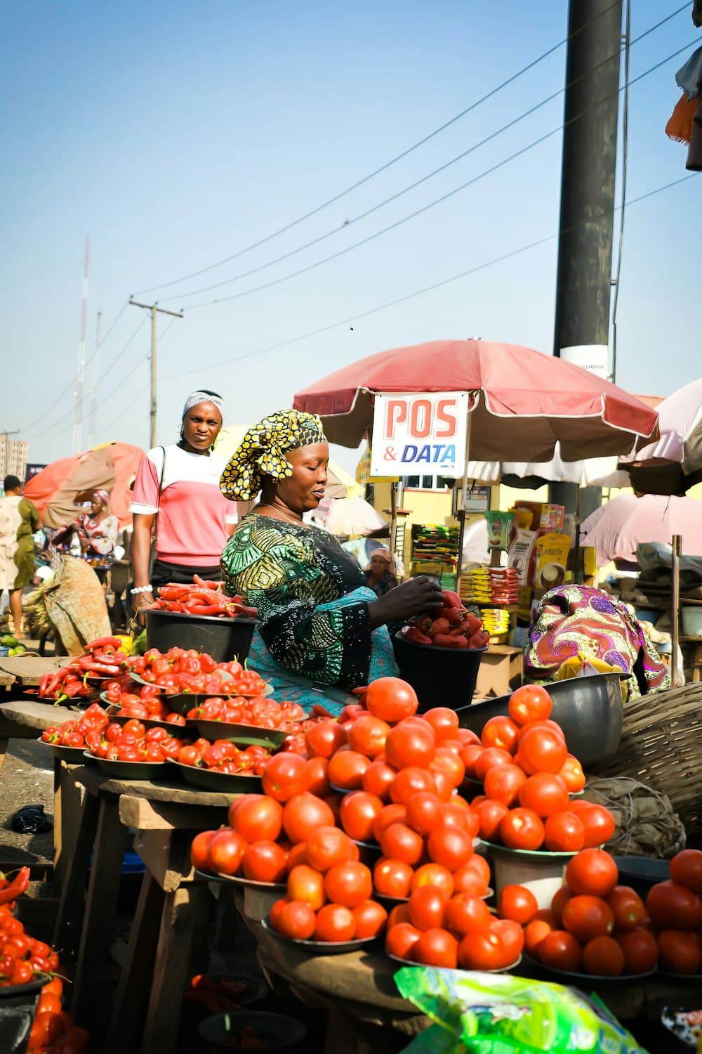 Commerçante vendant tomates et piments sur un marché
